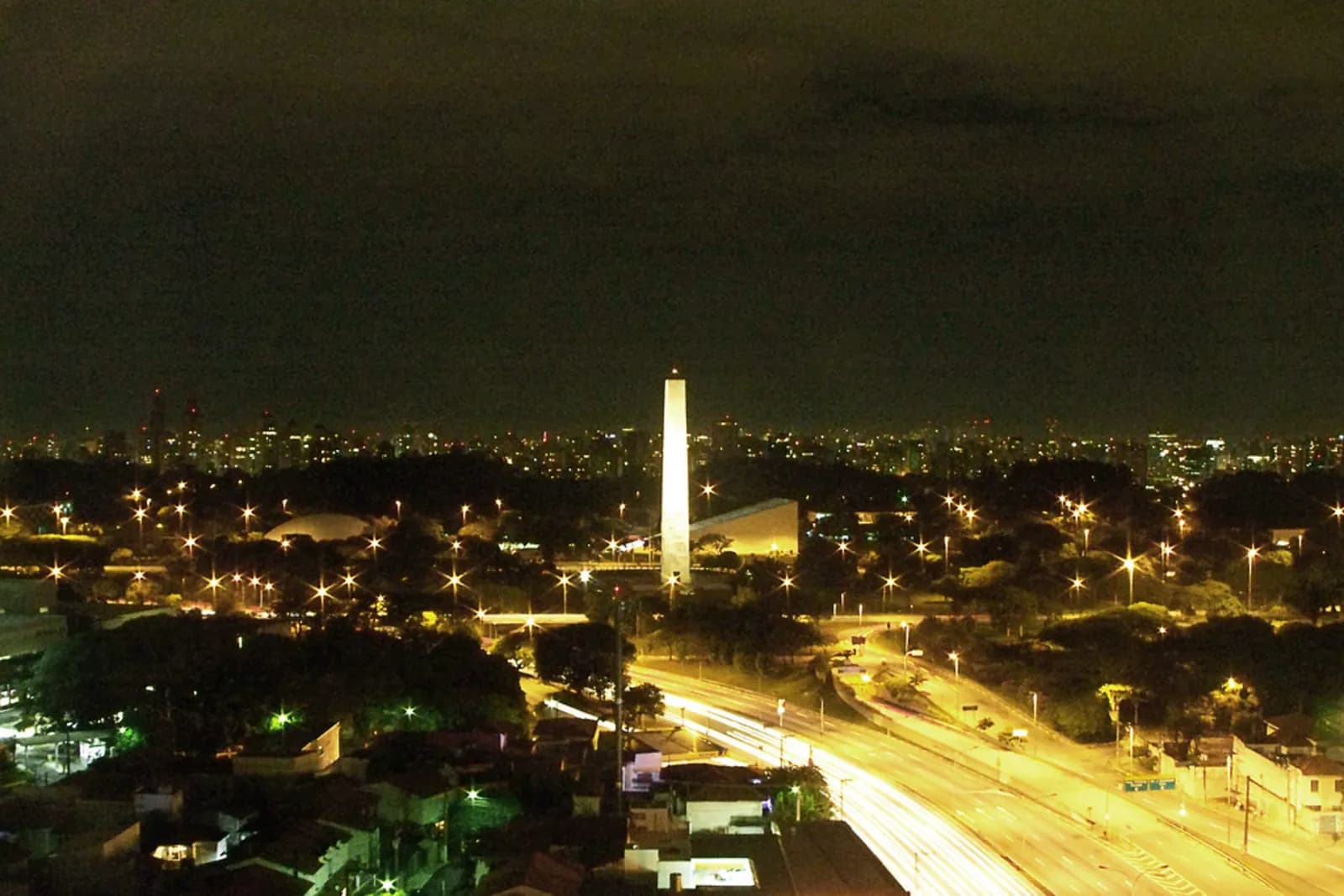 Parque Ibirapuera e o obelisco à noite, com a cidade de São Paulo ao fundo