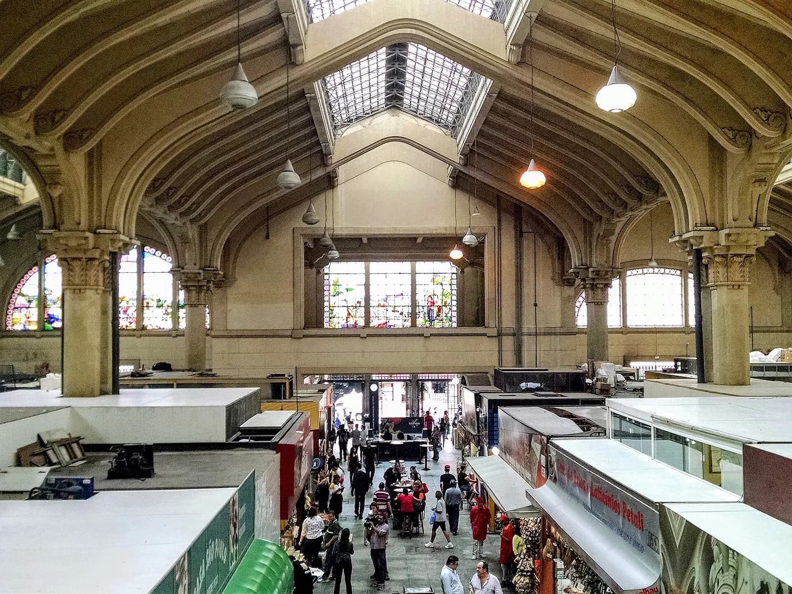 Interior do Mercado Municipal de São Paulo, com vitrais e bancas de frutas
